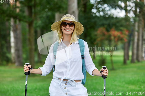 Image of young woman with nordic walk pols