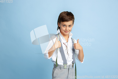 Image of Little boy dreaming about future profession of seamstress