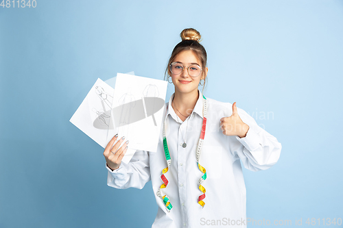 Image of Young girl dreaming about future profession of seamstress