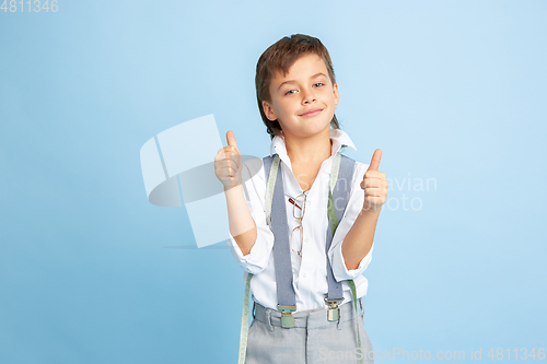 Image of Little boy dreaming about future profession of seamstress