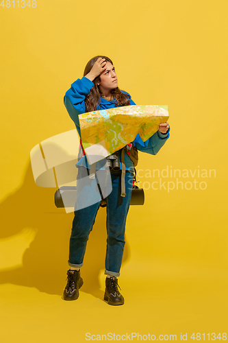 Image of Full length portrait of a cheerful young caucasian tourist girl isolated on yellow background