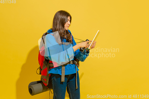 Image of Full length portrait of a cheerful young caucasian tourist girl isolated on yellow background