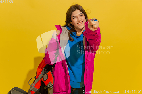 Image of Portrait of a cheerful young caucasian tourist girl isolated on yellow background