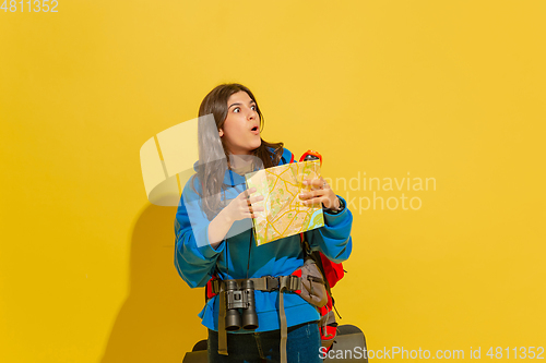 Image of Full length portrait of a cheerful young caucasian tourist girl isolated on yellow background