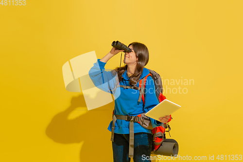 Image of Full length portrait of a cheerful young caucasian tourist girl isolated on yellow background