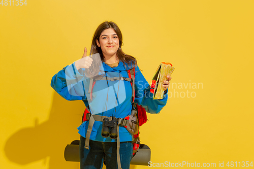 Image of Full length portrait of a cheerful young caucasian tourist girl isolated on yellow background