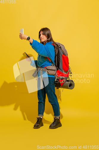 Image of Full length portrait of a cheerful young caucasian tourist girl isolated on yellow background