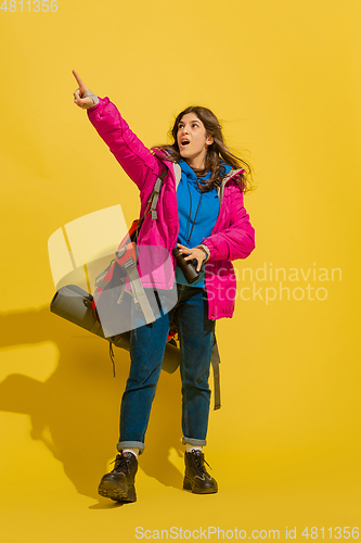 Image of Full length portrait of a cheerful young caucasian tourist girl isolated on yellow background