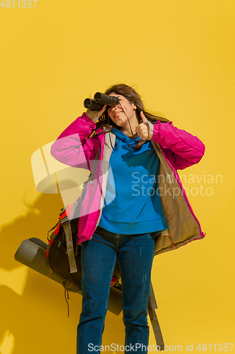 Image of Full length portrait of a cheerful young caucasian tourist girl isolated on yellow background