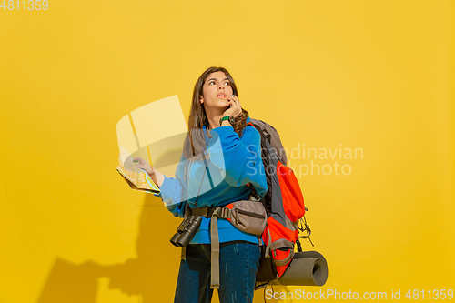 Image of Full length portrait of a cheerful young caucasian tourist girl isolated on yellow background