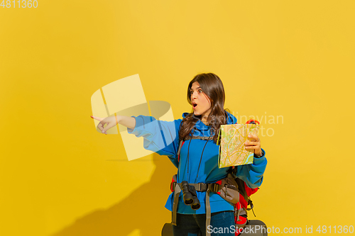 Image of Full length portrait of a cheerful young caucasian tourist girl isolated on yellow background