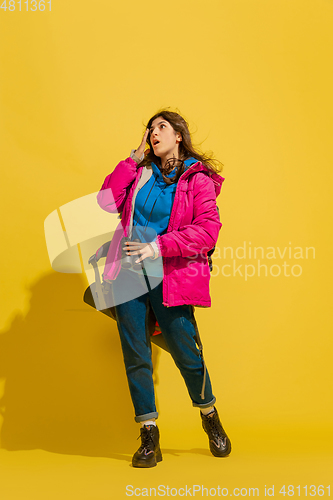 Image of Full length portrait of a cheerful young caucasian tourist girl isolated on yellow background