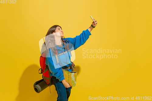 Image of Full length portrait of a cheerful young caucasian tourist girl isolated on yellow background