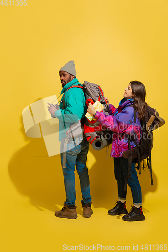 Image of Portrait of a cheerful young tourist couple isolated on yellow background