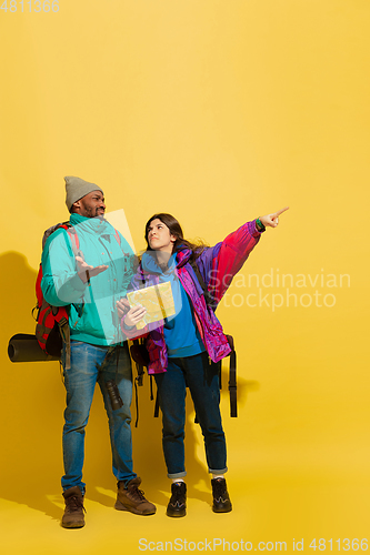Image of Portrait of a cheerful young tourist couple isolated on yellow background