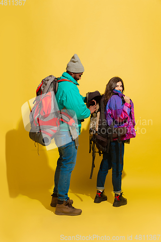 Image of Portrait of a cheerful young tourist couple isolated on yellow background