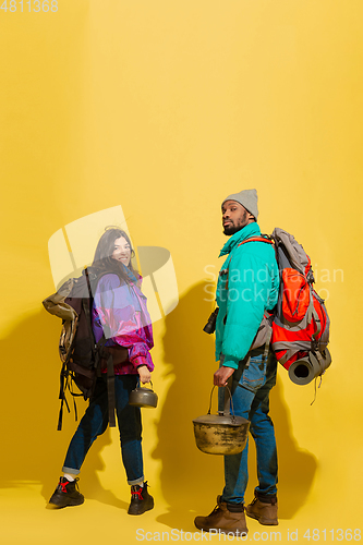 Image of Portrait of a cheerful young tourist couple isolated on yellow background