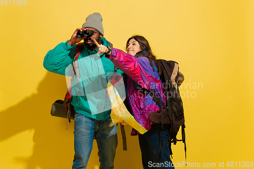 Image of Portrait of a cheerful young tourist couple isolated on yellow background