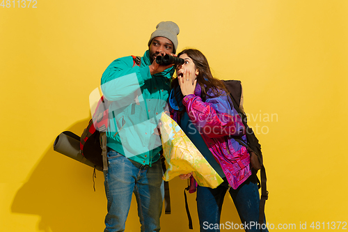 Image of Portrait of a cheerful young tourist couple isolated on yellow background