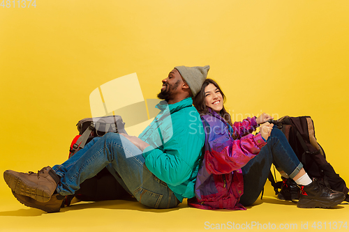 Image of Portrait of a cheerful young tourist couple isolated on yellow background