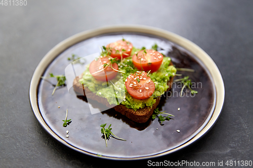 Image of toast bread with mashed avocado and cherry tomato