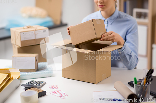 Image of woman packing parcel box at post office