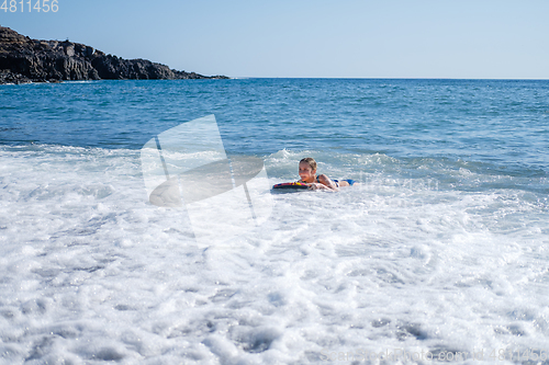 Image of girl swimming on board in ocean