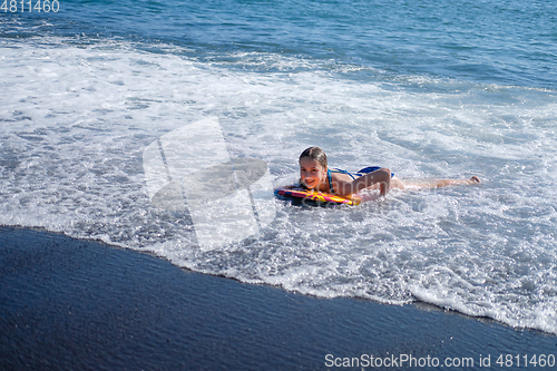 Image of girl swimming on board in ocean