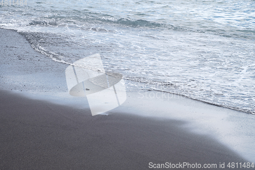 Image of ocean water on black sand