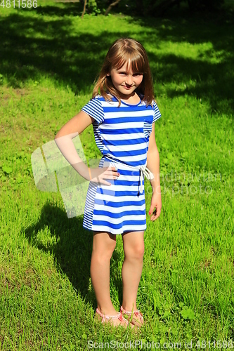 Image of sympathetic little girl lies on the grass