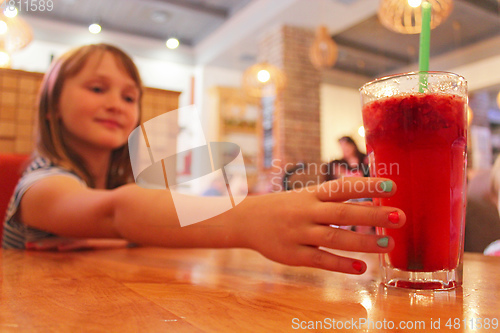 Image of young girl drinks a lemonade