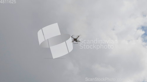 Image of Flying helicopter dron on a background of white clouds