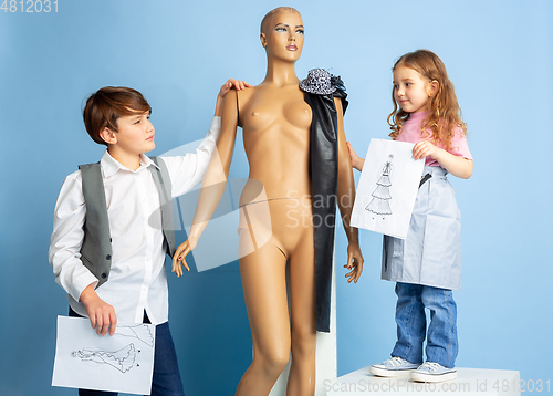Image of Little boy and girl dreaming about future profession of seamstress
