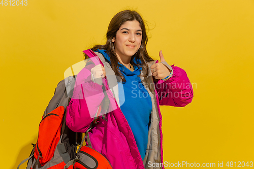 Image of Portrait of a cheerful young caucasian tourist girl isolated on yellow background