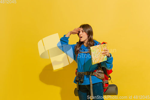 Image of Full length portrait of a cheerful young caucasian tourist girl isolated on yellow background