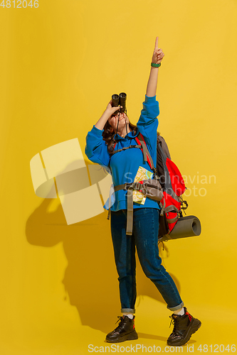 Image of Full length portrait of a cheerful young caucasian tourist girl isolated on yellow background