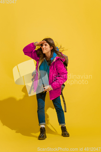 Image of Full length portrait of a cheerful young caucasian tourist girl isolated on yellow background