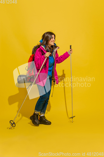 Image of Full length portrait of a cheerful young caucasian tourist girl isolated on yellow background