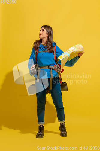 Image of Full length portrait of a cheerful young caucasian tourist girl isolated on yellow background