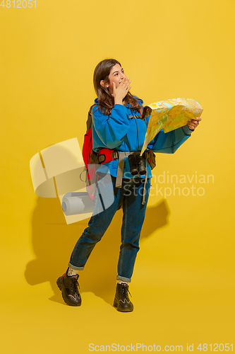 Image of Full length portrait of a cheerful young caucasian tourist girl isolated on yellow background