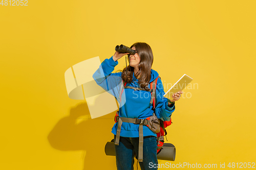 Image of Full length portrait of a cheerful young caucasian tourist girl isolated on yellow background