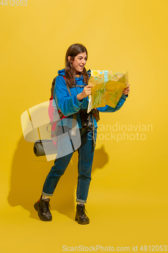 Image of Full length portrait of a cheerful young caucasian tourist girl isolated on yellow background