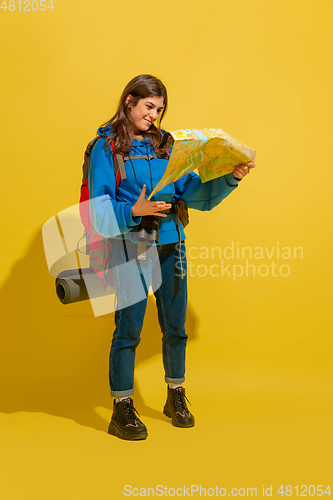 Image of Full length portrait of a cheerful young caucasian tourist girl isolated on yellow background