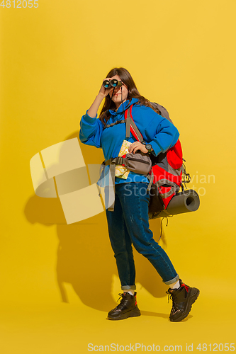 Image of Full length portrait of a cheerful young caucasian tourist girl isolated on yellow background