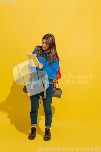 Image of Full length portrait of a cheerful young caucasian tourist girl isolated on yellow background