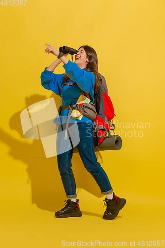 Image of Full length portrait of a cheerful young caucasian tourist girl isolated on yellow background