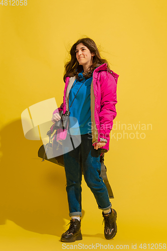 Image of Full length portrait of a cheerful young caucasian tourist girl isolated on yellow background