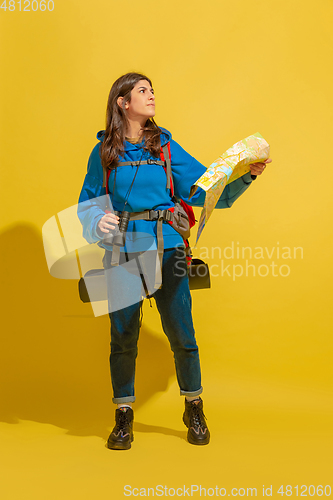 Image of Full length portrait of a cheerful young caucasian tourist girl isolated on yellow background