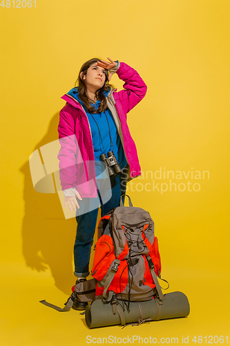 Image of Full length portrait of a cheerful young caucasian tourist girl isolated on yellow background