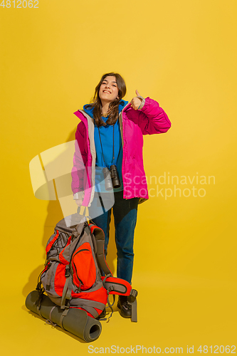 Image of Full length portrait of a cheerful young caucasian tourist girl isolated on yellow background